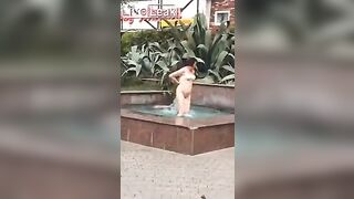 Naked woman enjoying the fountain