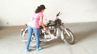 Curvy Indian chick handstarting her motorbike.